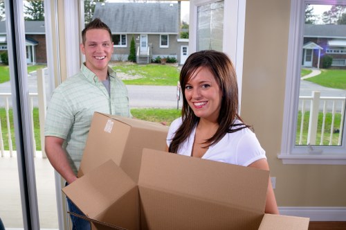 Removalists carrying furniture in a Watford property